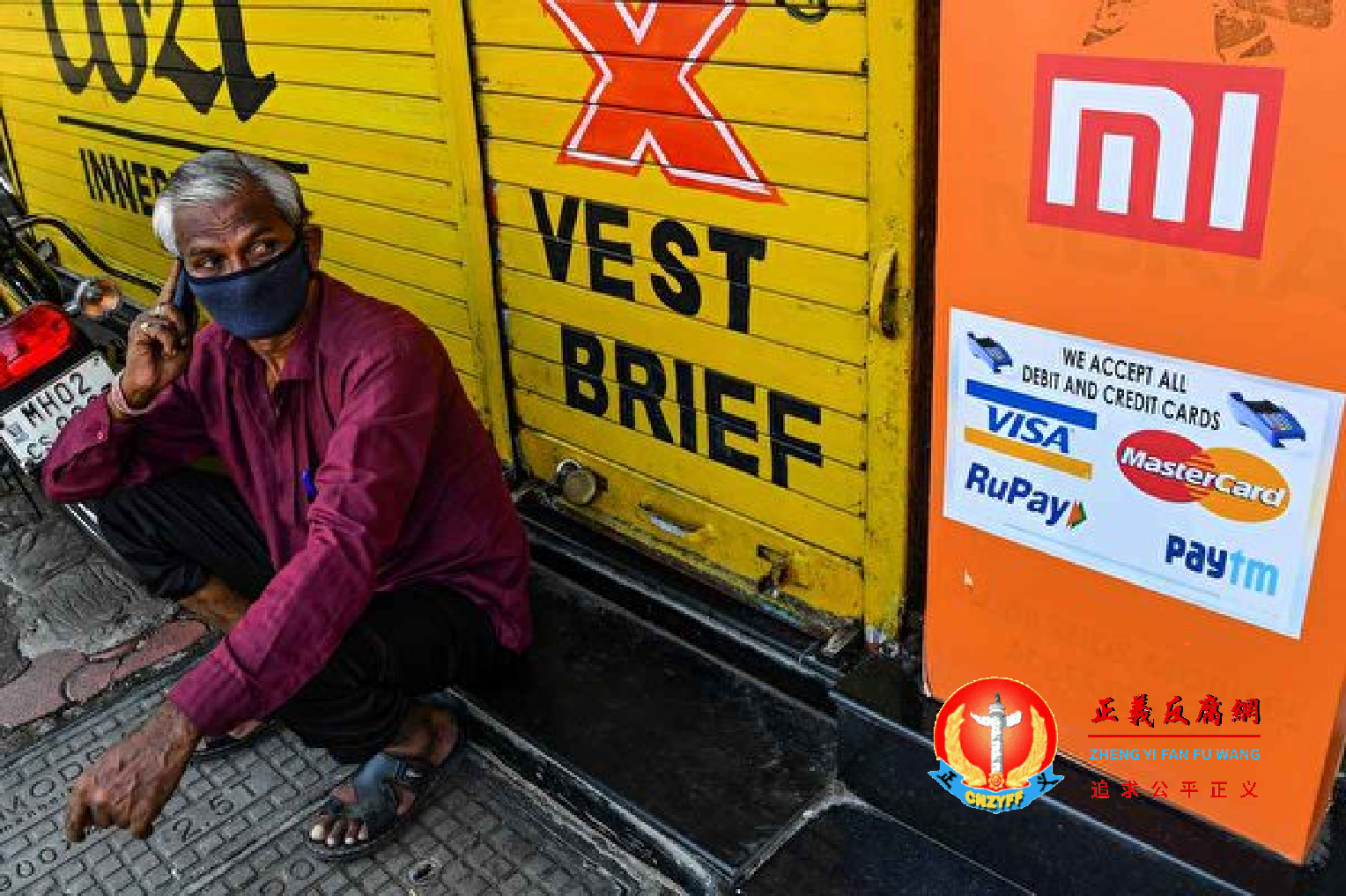 2022年6月25日,一名印度男子在销售小米手机的店铺前打电话。.png 2022年6月25日,一名印度男子在销售小米手机的店铺前打电话。.png